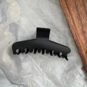Vue détaillée de la pince à cheveux noire mate montrant les dents et la prise de qualité
