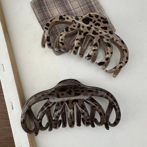 Detail of large leopard print hair claws in dark brown and light coffee glossy finishes