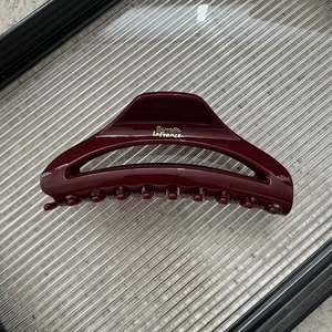 Detail view of burgundy crescent hair claw clip with silver Barrette LaFrance text