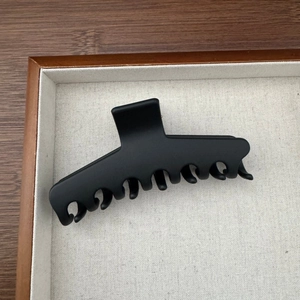 Vue détaillée de la grande pince à cheveux en silicone noir mat au design incurvé