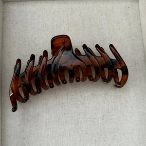 Détail d'une grande pince à cheveux en écaille de tortue polie sur un support en tissu