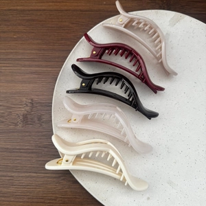 Close-up of heart-shaped hair clips in various colors arranged on a decorative marble tray