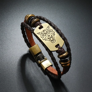 Detailed close-up of multi-layer leather bracelet featuring bronze wolf head and metal beads