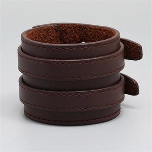 Detail eines dunkelbraunen doppellagigen breiten Lederarmbands im Punk-Stil mit Nähten