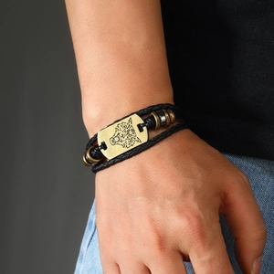 Men's punk leather bracelet featuring a vintage gold wolf head charm on woven strap