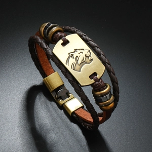Macro shot of punk style brown leather bracelet with bronze tiger head plate and beads