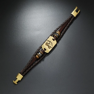Detailed macro of a multi-layer leather bracelet featuring a vintage bronze leopard head plate