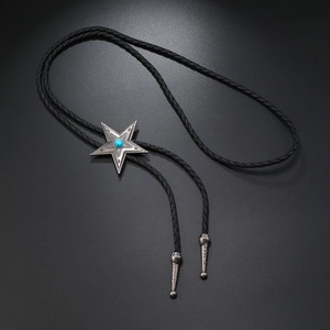 Detalle de corbata bolo estrella de plata vintage con turquesa y puntas de metal talladas