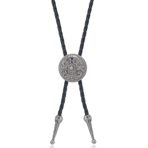 Detail of vintage silver floral engraved slide and braided leather cord on Bolo Tie