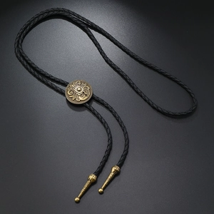 Detailed close-up of a vintage western bolo tie with bronze floral sliding buckle