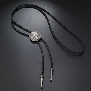 Detail of vintage flower engraved sliding buckle on black leather braided bolo tie necklace