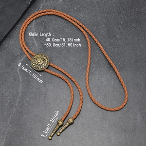 Antique bronze bolo tie with floral engraved slider and leather rope showing dimensions
