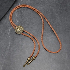 Vintage bronze western bolo tie with floral engraving on brown braided leather cord