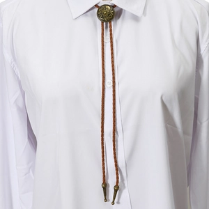 Detail of vintage bronze floral bolo tie with brown braided cord on a white shirt