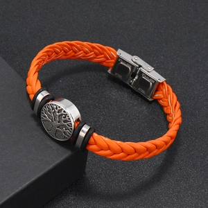 Detailed macro of orange braided leather bracelet with silver Tree of Life charm and steel clasp