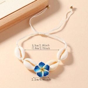 Adjustable woven shell anklet with blue flower detail and natural cowrie shells