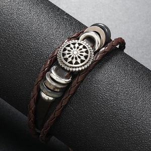 Bracelet multicouche en cuir avec breloque tournesol et cordons tressés sur support noir