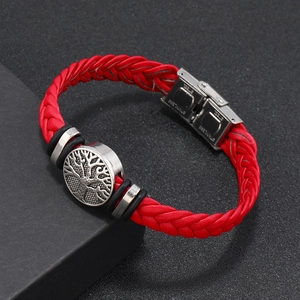 Detail shot of a red woven leather bracelet featuring a stainless steel tree of life charm