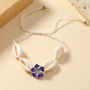 Detail of bohemian shell anklet with purple flower and adjustable white woven cord