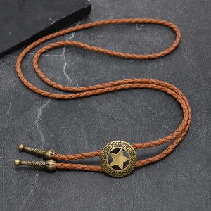 Dettaglio del bolo tie vintage con medaglione a stella dorata e cinturino in pelle intrecciata