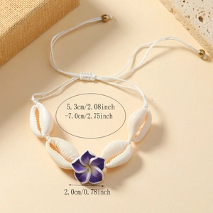 Detail of bohemian shell anklet with a purple flower and adjustable white woven cord