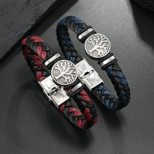 Close-up of woven leather bracelets with Tree of Life charms and stainless steel clasps