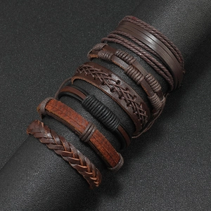 Close-up of multilayered brown braided leather bracelet set for men on black display