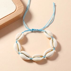 Close-up of handmade blue cord shell bracelet with adjustable natural white shells