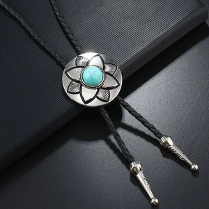 Detailed macro view of a vintage flower bolo tie with turquoise stone and silver alloy