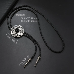Macro detail of western floral bolo tie featuring black gemstone and silver aglets