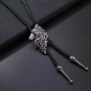 Detalle de la corbata de bolo con cabeza de lobo y cordón trenzado negro