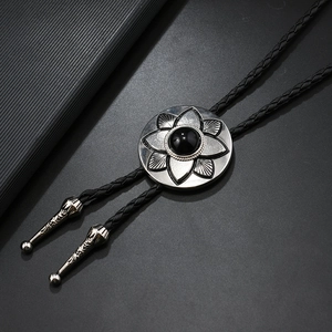 Detail of a vintage bolo tie with a flower-patterned silver slide and black gemstone