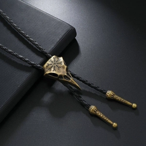 Primer plano del bolo tie de calavera de cuervo en bronce con símbolo vikingo Vegvísir