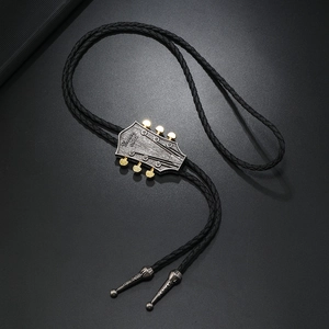 Dettaglio del cravattino bolo a forma di chitarra con incisione Country Music su nero