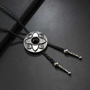 Close-up of vintage flower bolo tie slider with black gemstone and silver petal relief