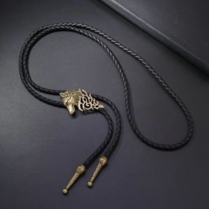 Vista detallada del colgante de cabeza de lobo dorado y cordón trenzado negro para bolo tie