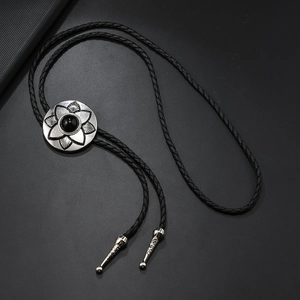 Vintage flower bolo tie with black stone inlay on woven cord with metal tips