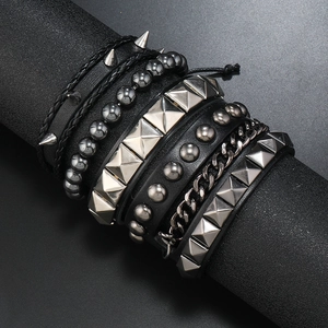 Set of 6 punk rock bracelets with studs and chains on a black display stand