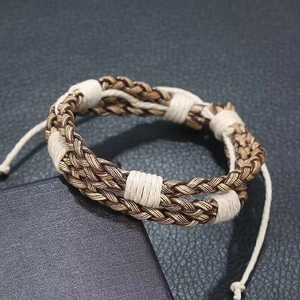 Detail of multi-strand braided leather bracelet with adjustable rope closure for men