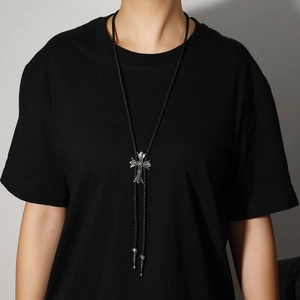 Detail der Vintage Gothic Kreuz Bolo Tie mit gravierten Metallspitzen an schwarzer Kordel