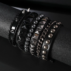 Detailed close-up of multi-layer black leather punk bracelets with metal studs and chains
