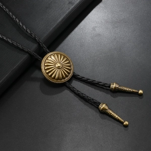 Macro detail of bronze flower sunburst bolo tie pendant with black braided cord