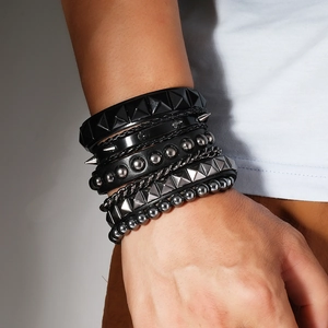 Macro shot of punk multilayer leather bracelets with metal studs and heavy chains