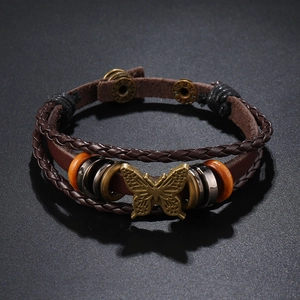 Makroaufnahme des mehrlagigen Lederarmbands mit Bronze-Schmetterling und Druckknopfverschluss