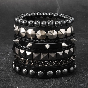 Detailed close-up of multi-layer punk leather bracelet with silver metal studs and chains