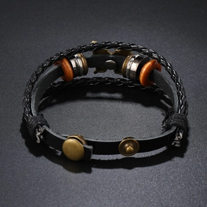 Detailansicht eines mehrlagigen Lederarmbands mit Schmetterling und Druckknopfverschluss