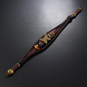 Detail eines mehrlagigen Lederarmbands mit Bronze-Schmetterling und Holzperlen