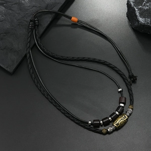 Detail view of woven wax cord necklace with tribal totem beads and metal accents