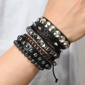 Macro detail of multi-layer punk leather bracelet with metal studs and chains