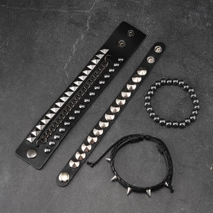 Macro shot of a four-piece punk bracelet set with silver studs and metal chains